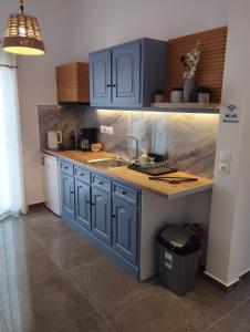 a kitchen with blue cabinets and a sink at Buenavista apartment in Ipsos
