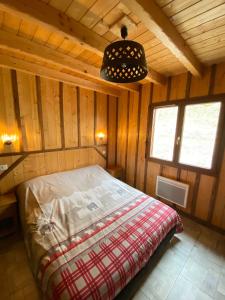 a bedroom with a bed in a wooden cabin at LE GRENIER DES MIOS in La Bresse +8 photos