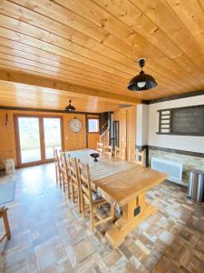 a large dining room with a wooden table and chairs at LE GRENIER DES MIOS in La Bresse +8 photos