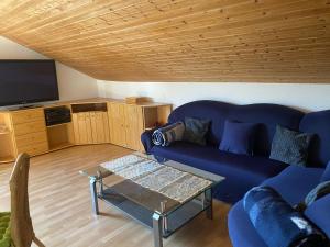 Una sala de estar con un sofá azul y una mesa. en Ferienwohnung Münnerstadt, en Münnerstadt