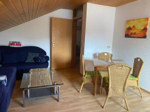 Una sala de estar con un sofá, una mesa y sillas. en Ferienwohnung Münnerstadt, en Münnerstadt
