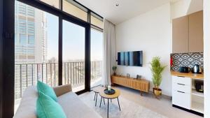 a living room with a couch and a large window at The Community Jumeirah Village in Dubai
