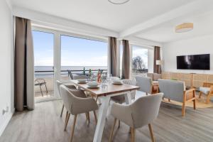格洛米茨Beachside Grömitz - 21 traumhafte Apartments mit Pool & Sauna direkt am Strand的享有美景的带桌椅的用餐室