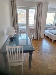 mesa de comedor con lámpara y 2 sillas en Studio Flat Medien Hafen 30minToFair, en Düsseldorf