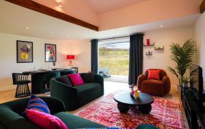 a living room with two couches and a table at Moonlight Lodge - 4 bedroom Barn with Hot Tub! in Godstone