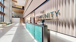 a lobby with a company sign on a wall at The Community Jumeirah Village in Dubai