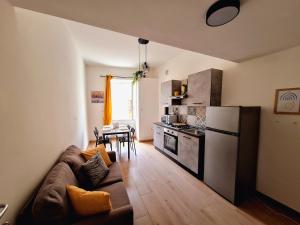 ein Wohnzimmer mit Couch und Küche in der Unterkunft Elunà Assisi Home in Assisi + 23 Fotos