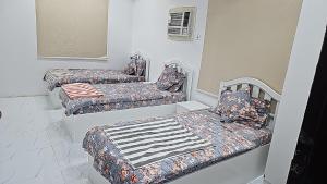 two twin beds in a room with avisor at Welcome Two 5km far from Masjid Nabawi in Al Madinah