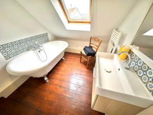 ein Badezimmer mit einer weißen Badewanne und einem Waschbecken in der Unterkunft Madeleine - Maison élégante tout confort au cœur de Berck-Plage in Berck-sur-Mer