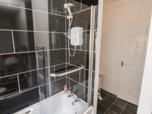 a bathroom with a shower and a bath tub at Caedmon's Rest in Whitby +22 photos