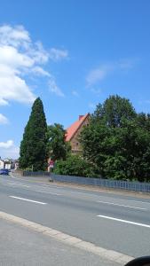 a road with a fence and trees on the side at Monteurzimmer Beate Ackermann in Hochstadt am Main