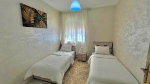 a bedroom with two beds and a blue light at T6 Luxury in Témara Discover a Comfortable Apartment in Temara