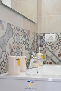 a bathroom with two cups on a sink at Scaglione Palace in Gallipoli