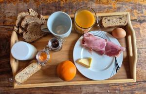a tray with a plate of food and bread and eggs at Le refuge des3petitscochons in Lalizolle
