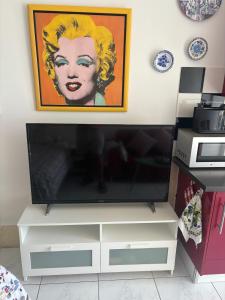a flat screen tv sitting on top of a white entertainment center at Nice Studio Apartment with Ocean View in Arguineguín +2 photos