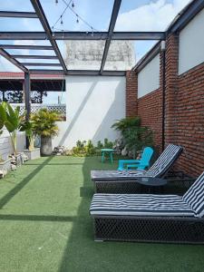 eine Terrasse mit zwei Gartenstühlen und einem Tisch in der Unterkunft Duplex en Getsemani TWON in Cartagena de Indias + 12 Fotos