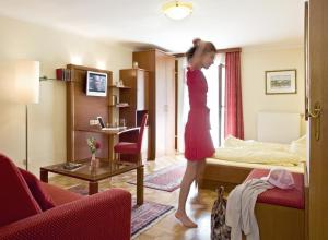 Una chica con un vestido rojo caminando en una habitación de hotel en Landgasthof Zur schönen Wienerin, en Marbach an der Donau