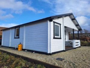 a white tiny house with a fire hydrant in front at Hillside Hideaway in Doonalt