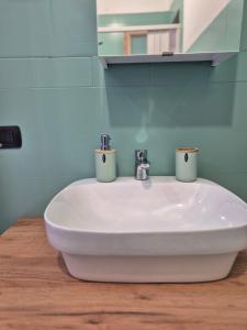 a bathroom sink with two cups on top of it at House del Levante Locazione turistica in Bari