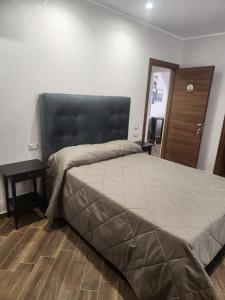 a bedroom with a large bed with a black headboard at Palazzo Grecale Dell'Etna in Aci SantʼAntonio +9 photos