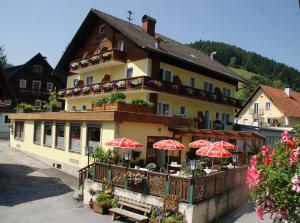 a building with red umbrellas in front of it at Landhotel-Restaurant Willingshofer in Gasen