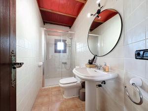 une salle de bain avec un lavabo, des toilettes et un miroir dans l'établissement Villa Tortugas, 5 min ibiza City, à Ibiza