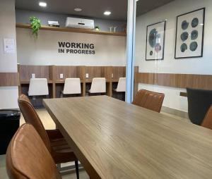 une salle de conférence avec une table et des chaises en bois dans l'établissement Bauru Apartamento Fly Aeroclube USP FOB Shopping Hospital, à Bauru