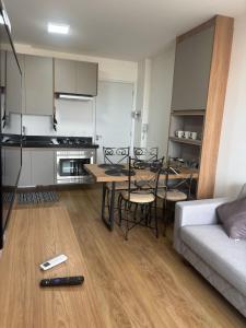 un salon avec un canapé, une table et des chaises dans l'établissement Bauru Apartamento Fly Aeroclube USP FOB Shopping Hospital, à Bauru