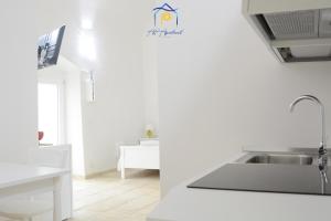 a white kitchen with a sink and a counter at Scaglione Palace in Gallipoli