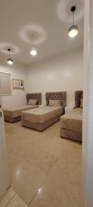ein Wohnzimmer mit 3 Betten und Beleuchtung in der Unterkunft شقة أرضية عائلية مكونة من 3 غرف نوم وصالة ومطبخ 7 in Riad