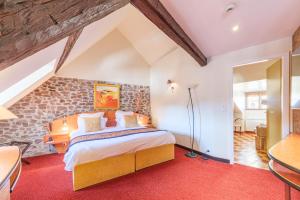 エギスハイムにあるL'Hostellerie du Châteauのベッドと石の壁のある寝室