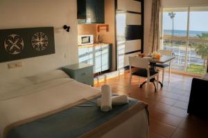sypialnia z łóżkiem i biurkiem oraz kuchnią w obiekcie Hotel Playa Conil - Beachfront Studios & Suites w mieście Conil de la Frontera
