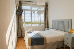 Łóżko lub łóżka w pokoju w obiekcie Hotel Playa Conil - Beachfront Studios & Suites