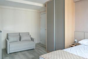 ein Schlafzimmer mit einem weißen Stuhl und einem Bett in der Unterkunft Studio em Boa Viagem Excelente localização in Recife