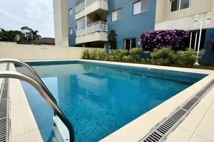 a swimming pool in front of a building at Apartamento em Bertioga - SP (2) in Ilha Monte Pascoal