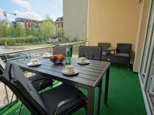 a table on a balcony with a drink and fruit on it at HOGULU - 3 - RAUM - App 25 mit Balkon in Brandenburg an der Havel
