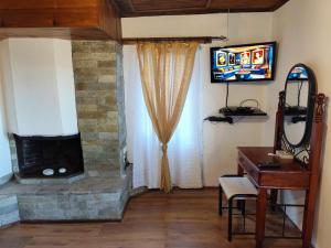 a living room with a stone fireplace and a television at Zagora MGHouse in Zagora