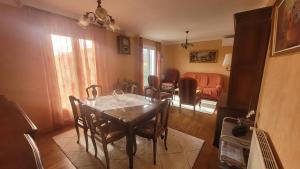 a dining room with a table and a living room at La Maison in Le Mas-dʼAzil