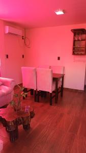 a living room with a table and pink lighting at Hospedaje in Jardín América