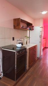 a kitchen with a stove and a refrigerator at Hospedaje in Jardín América