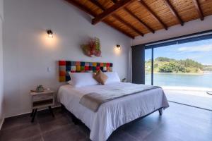 a bedroom with a bed with a view of the water at Jordan Hotel Boutique in Guatapé