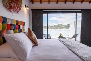 a bedroom with a large bed with a view of the water at Jordan Hotel Boutique in Guatapé
