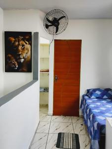 a room with a bed and a fan next to a door at Apartamento Cavalcante in Belém