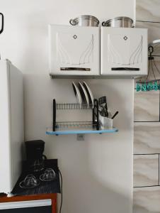 a kitchen with white cabinets and a shelf with utensils at Apartamento Cavalcante in Belém