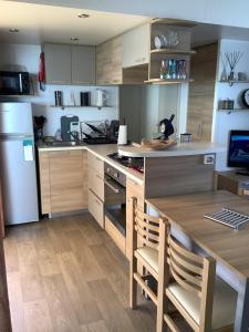 a kitchen with wooden cabinets and a counter with a table at Montourey 83 ES 119 in Fréjus