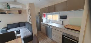 a small kitchen with a couch and a sink in a room at Mh 131 Bois Dormant fond d'impasse, 6 personnes in Saint-Jean-de-Monts