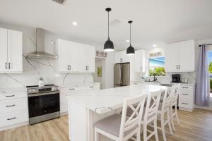 a kitchen with white cabinets and a large white island at Anchors Away by Sun Palace Vacations in Fort Myers Beach