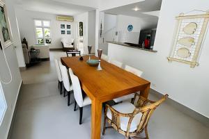 a dining room and kitchen with a wooden table and chairs at Casa de condomínio em Juquehy - SP (4) in Praia de Juquehy