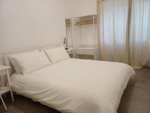 a white bed with white sheets and pillows in a bedroom at Casa San Nicolò in Scicli