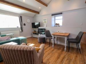 a living room with a couch and a table with chairs at Shay Bank Cottage in Keighley